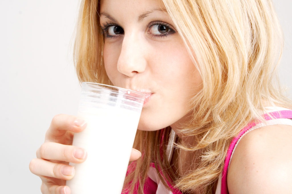 teenage blond girl drinks milk